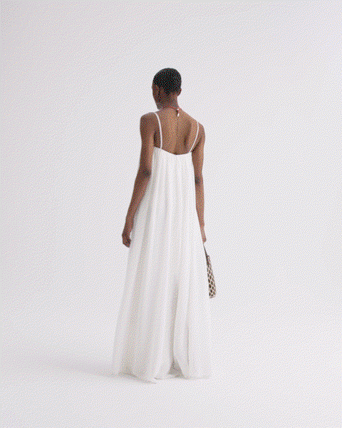 GIF of a model turning in a white dress.
