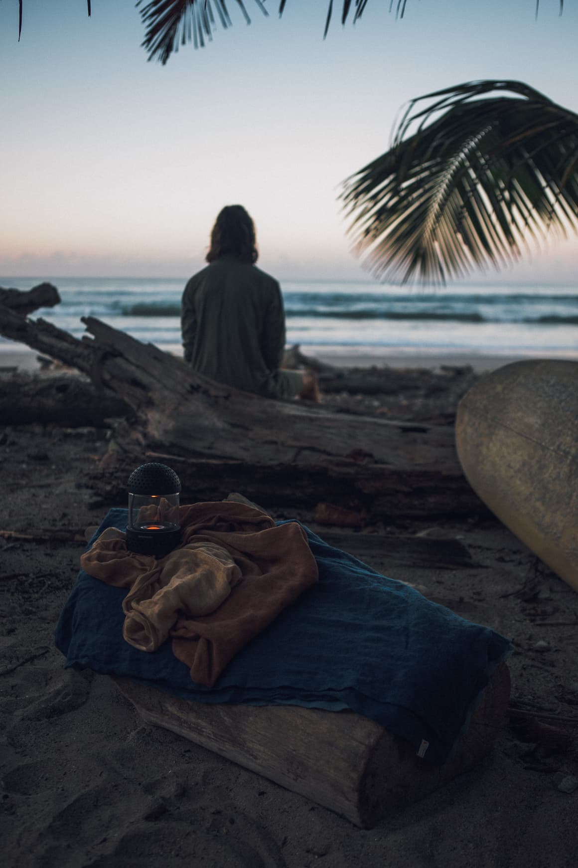 Transparent Light Speaker in Black on a blanket on the beach