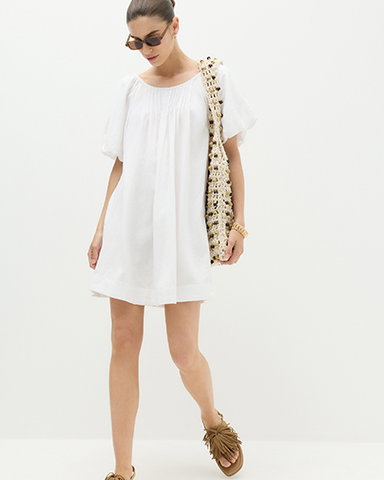 Woman wearing a White Linen Rich Puff Sleeve Mini Smock Dress and Natural Mix Macrame Beaded Shoulder Bag