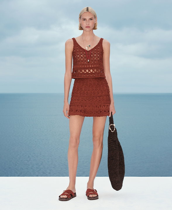 Woman wearing a Brandy Crochet-Style Cropped Knitted Top and Mini Skirt