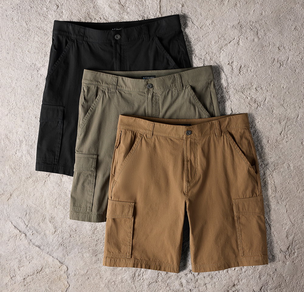 Three pairs of earth-toned shorts against a rocky background.