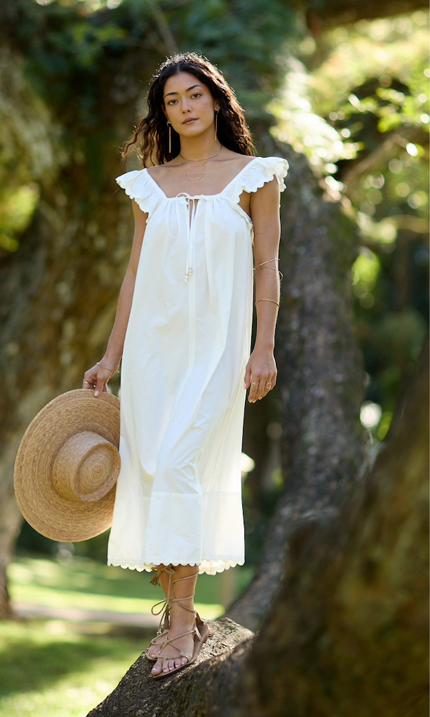 Woman wearing a white dress standing on a tree