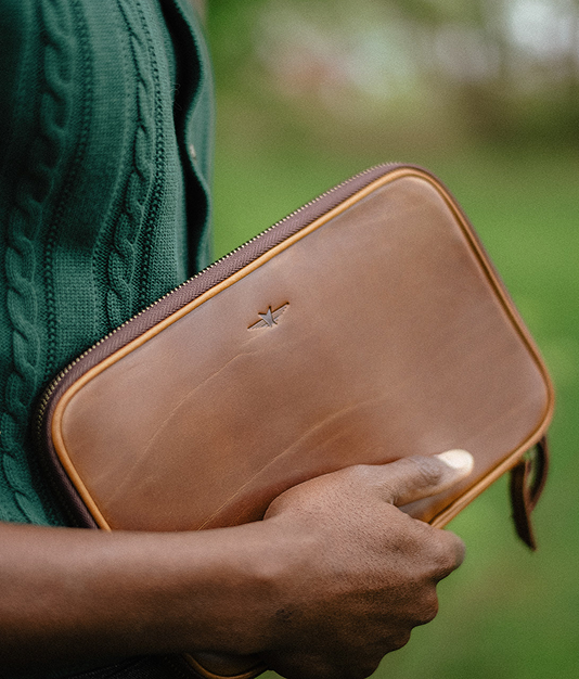 Hand holding a brown leather card wallet