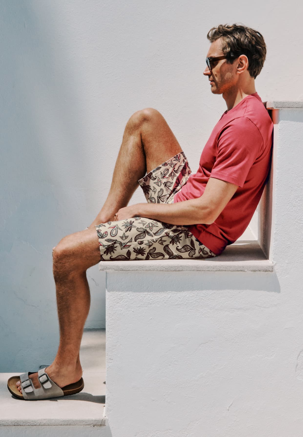 male model sitting on steps outdoors wearing Living t-shirt and Night and Day shorts