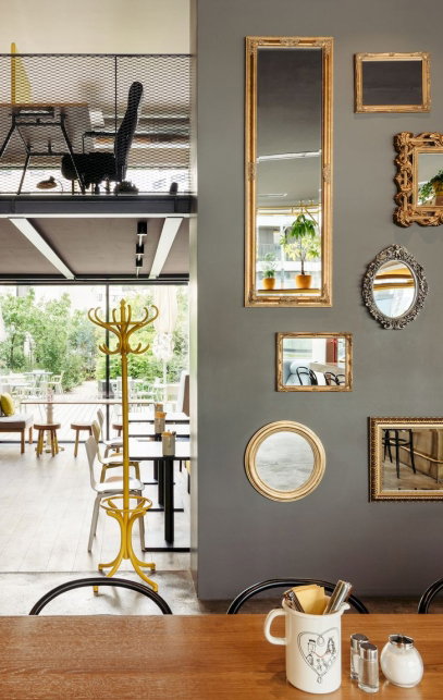 Hotelrestaurant mit Tischen und Spiegeln und Bildern an der Wand