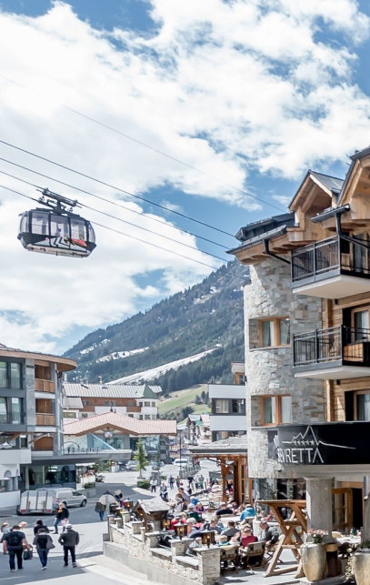 Hotel Außensicht mit Bergblick und Gondel im Hintergrund