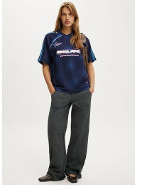 Woman wearing navy graphic t-shirt and charcoal pants