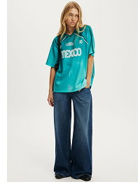 Woman wearing teal graphic t-shirt and navy wide-leg jeans