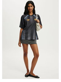 Woman wearing black striped oversized shirt and dark skirt