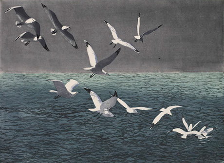 Flock of water birds flying through a stormy grey sky above choppy water. - Custom Print.