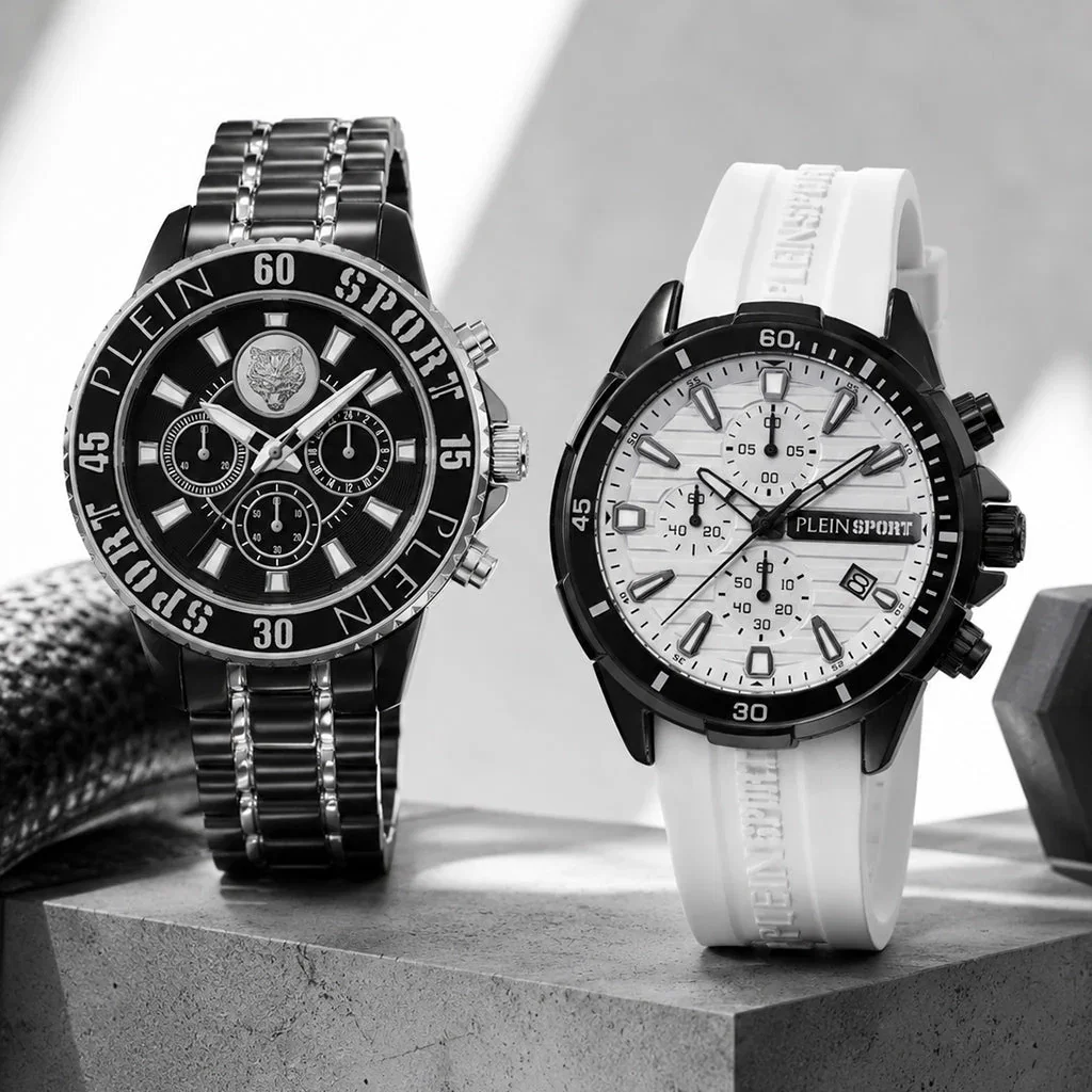 Two Plein Sport chronograph watches displayed on concrete: black metal band with black dial, white rubber band with white dial.