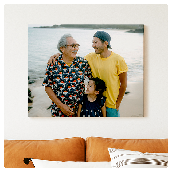A 16x20 canvas hung above a couch shows three generations of a family enjoying time together at a lake.