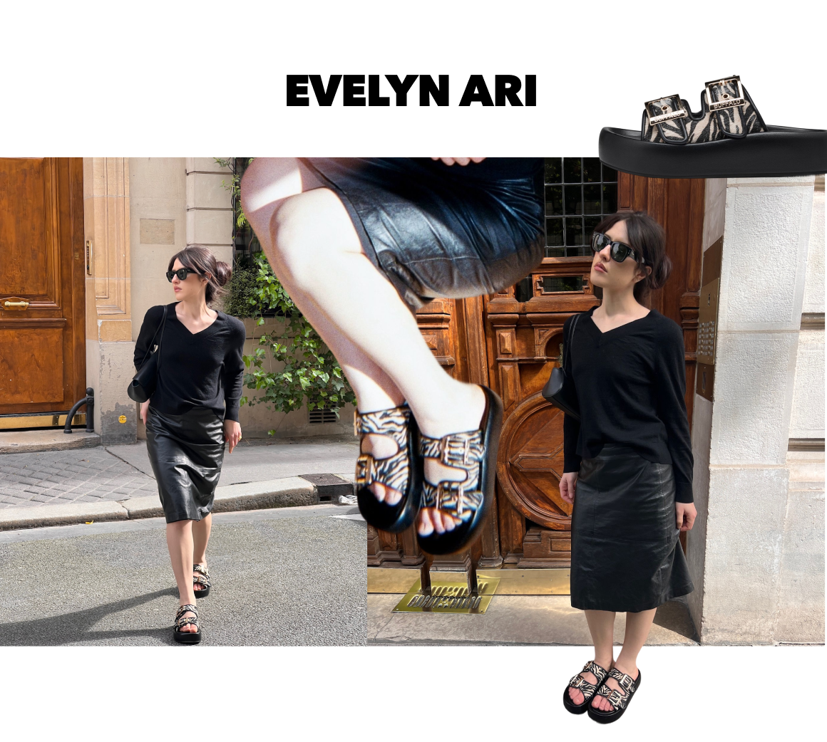 Black patterned buckle sandals with chunky sole, styled in an urban street setting with casual all-black outfit.