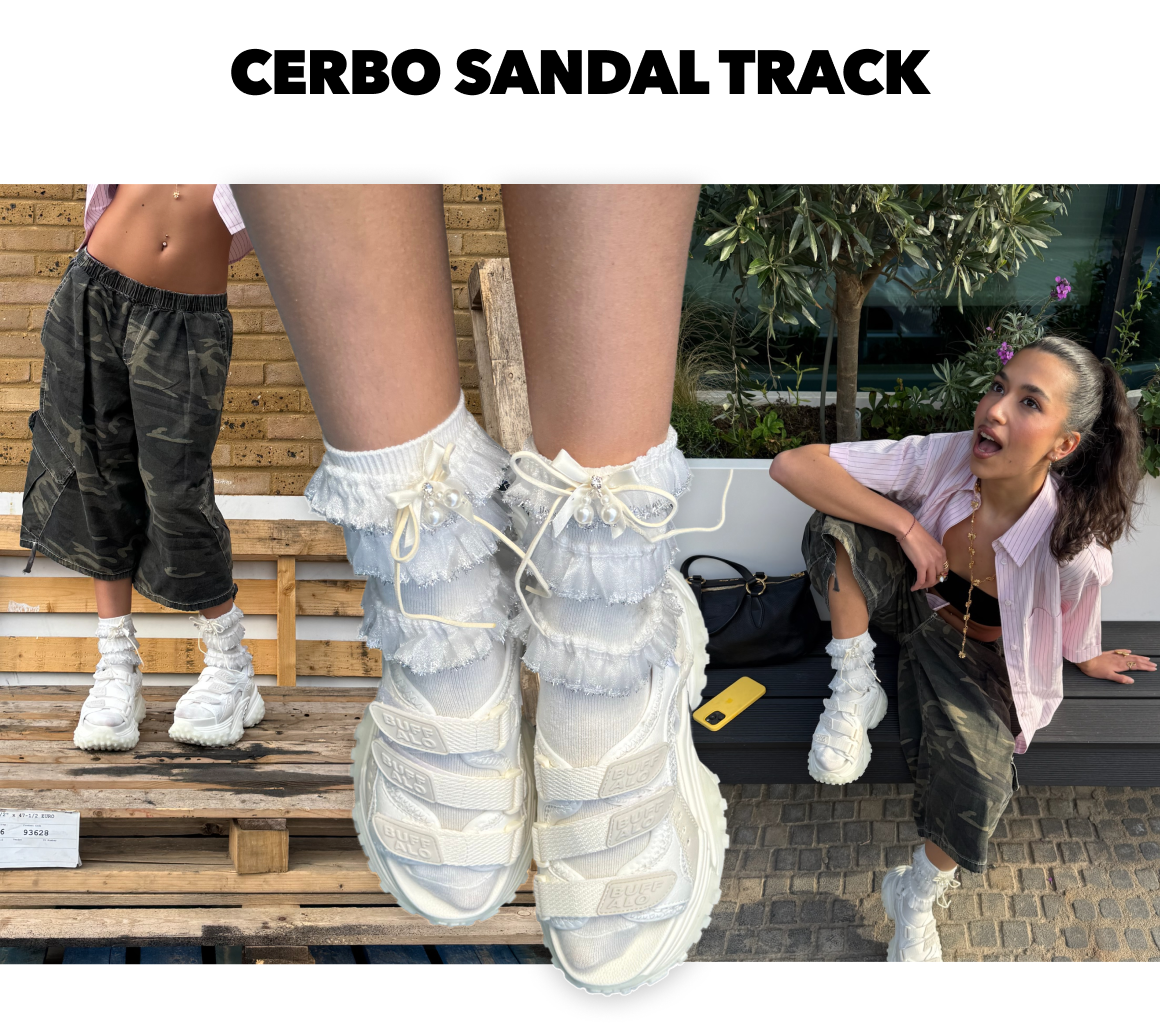White sporty track sandals with layered strap design, styled with ruffled socks in a casual streetwear setting.