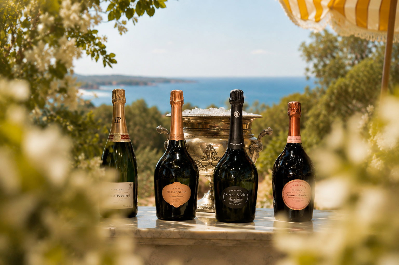 Four champagne bottles and silver ice bucket on marble table overlooking sunlit Mediterranean sea, summer terrace scene