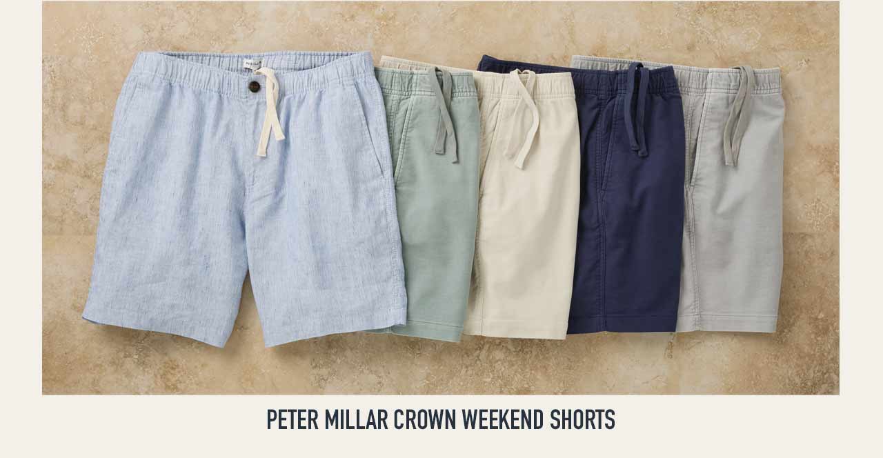 Peter Millar Crown Weekend Shorts in five colors — blue chambray, sage, cream, navy, and gray — laid flat in a fan arrangement