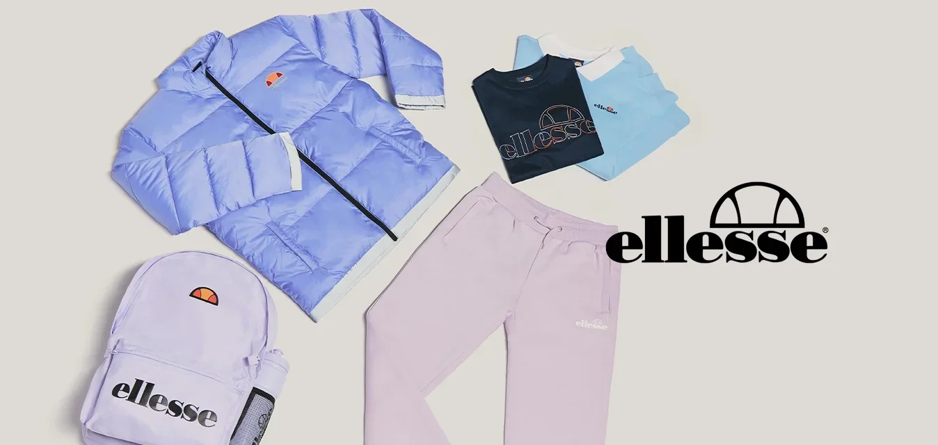 Hellblaues Pufferjacke, passender Rucksack, lilafarbene Jogginghosen und drei gefaltete T-Shirts in Marineblau, Weiß und Hellblau auf beigem Hintergrund.