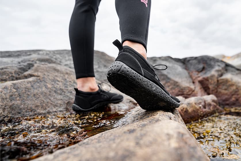 Person med badskor på klippstrand