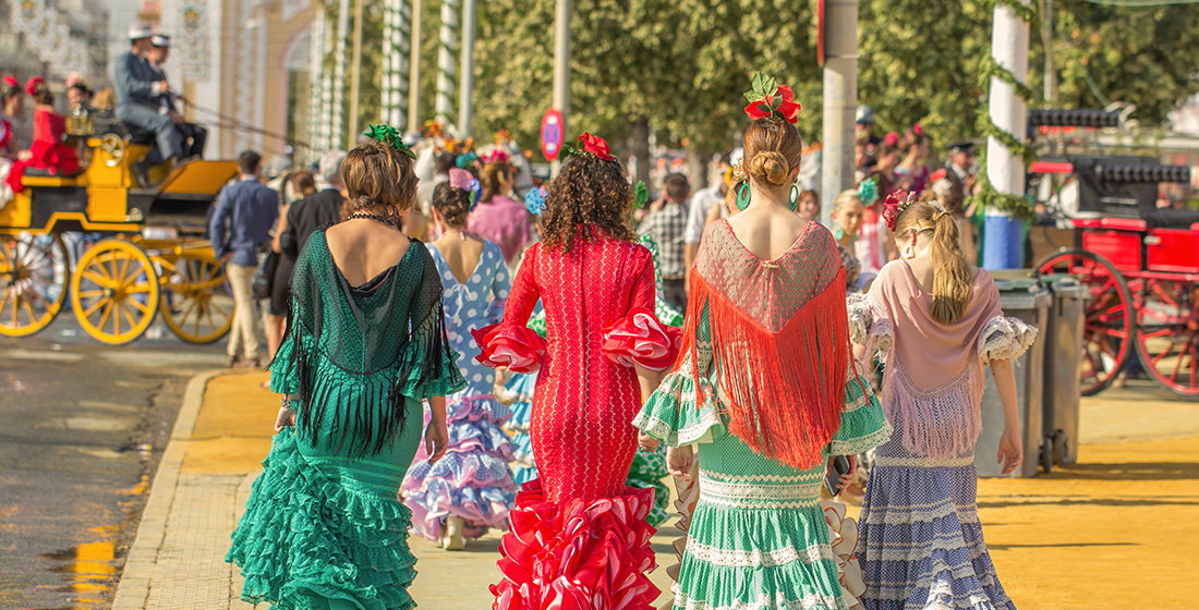 A group of women dressed in traditional dresses for Feria de Abril in Seville, Spain