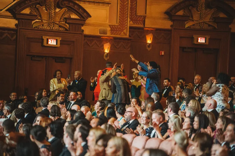 A crowd of people celebrating a JBF award in a theater.