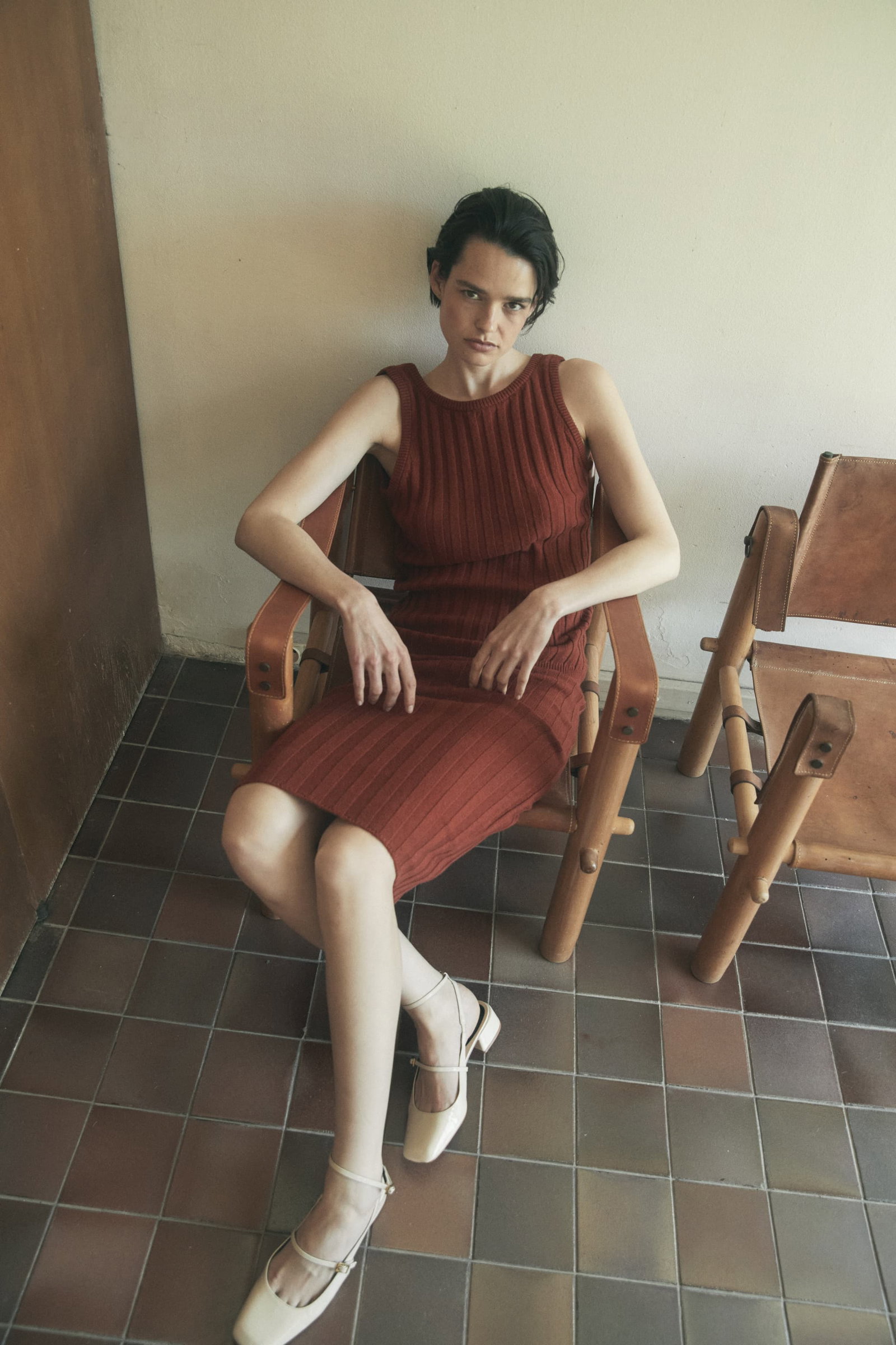 an image of a woman sitting on a chair in a yellow dress