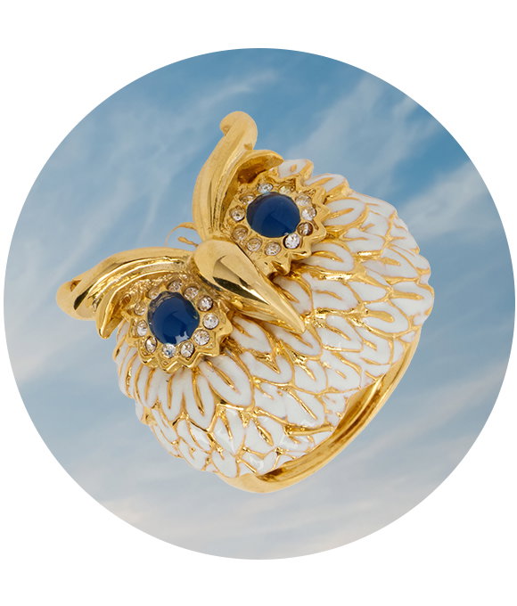 Gold owl ring with white detailing and blue gemstone eyes.