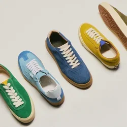 Zeven casual suède sneakers in verschillende kleuren, waaronder blauw, groen, geel en paars, in een rij gerangschikt op een lichte achtergrond.
