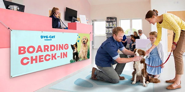 An indoor banner hangs from the check-in desk at a dog boarding and grooming business.