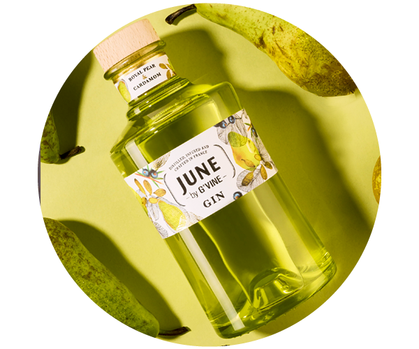 Bottle of JUNE by G'Vine pear‑infused gin on a green background, labelled bottle arranged with fresh pears