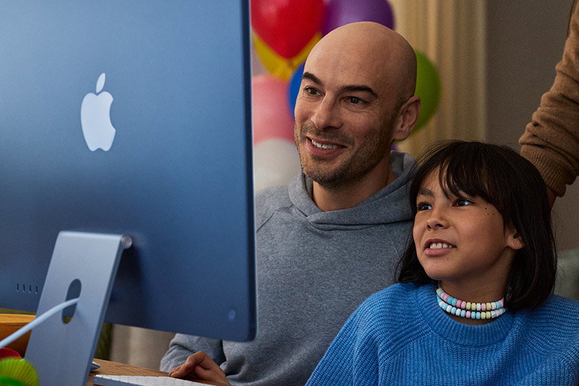 Parents and child view an iMac in Blue