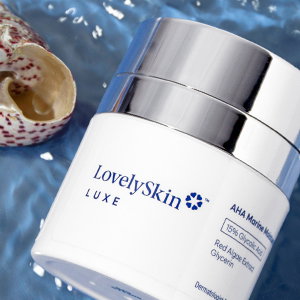 LovelySkin LUXE jar laying in water next to a brown and white spotted seashell