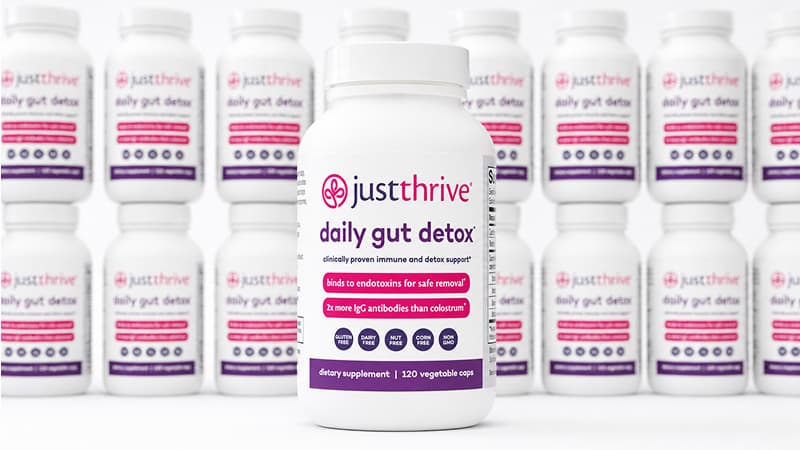 Just Thrive Daily Gut Detox bottles stacked in background with one bottle in center forefront