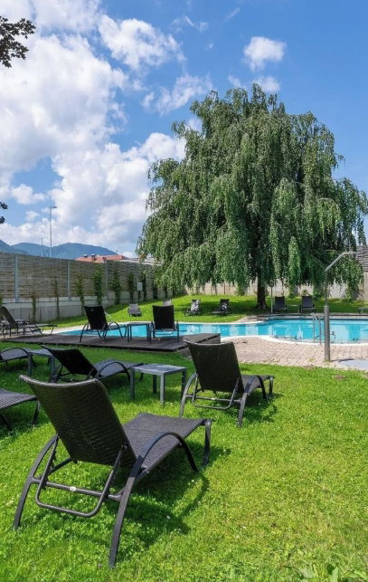 Hotel Garten mit Pool und Liegen und Blick zum See
