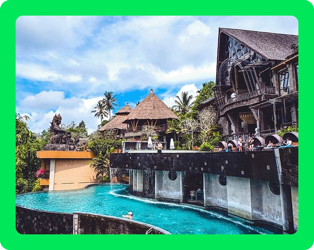 Image Description: A hotel overlooking a pool in the jungle.
