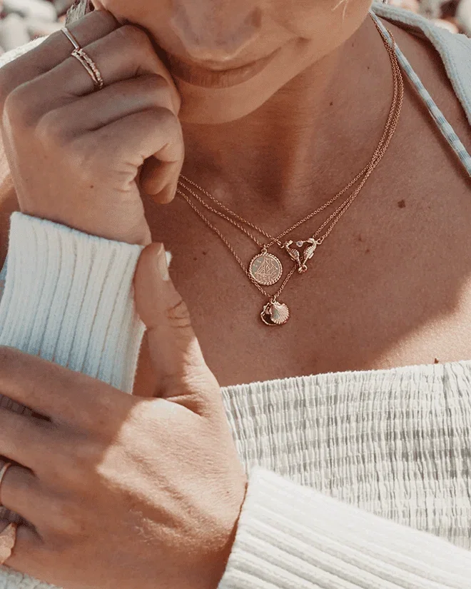 Array of ocean inspired gold jewellery from Alex Monroe on model