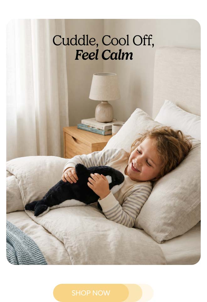 A little girl snuggling Orca Warmies. Shop Now.