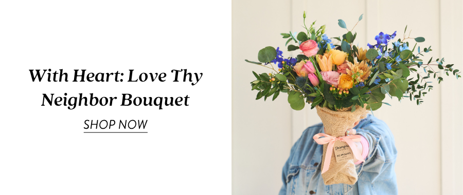 Product feature for “With Heart: Love Thy Neighbor Bouquet,” showing a burlap-wrapped bouquet with yellow, pink, blue, peach, and green flowers held in front of someone wearing denim. Text on the left reads “With Heart: Love Thy Neighbor Bouquet” with a “Shop Now” link.