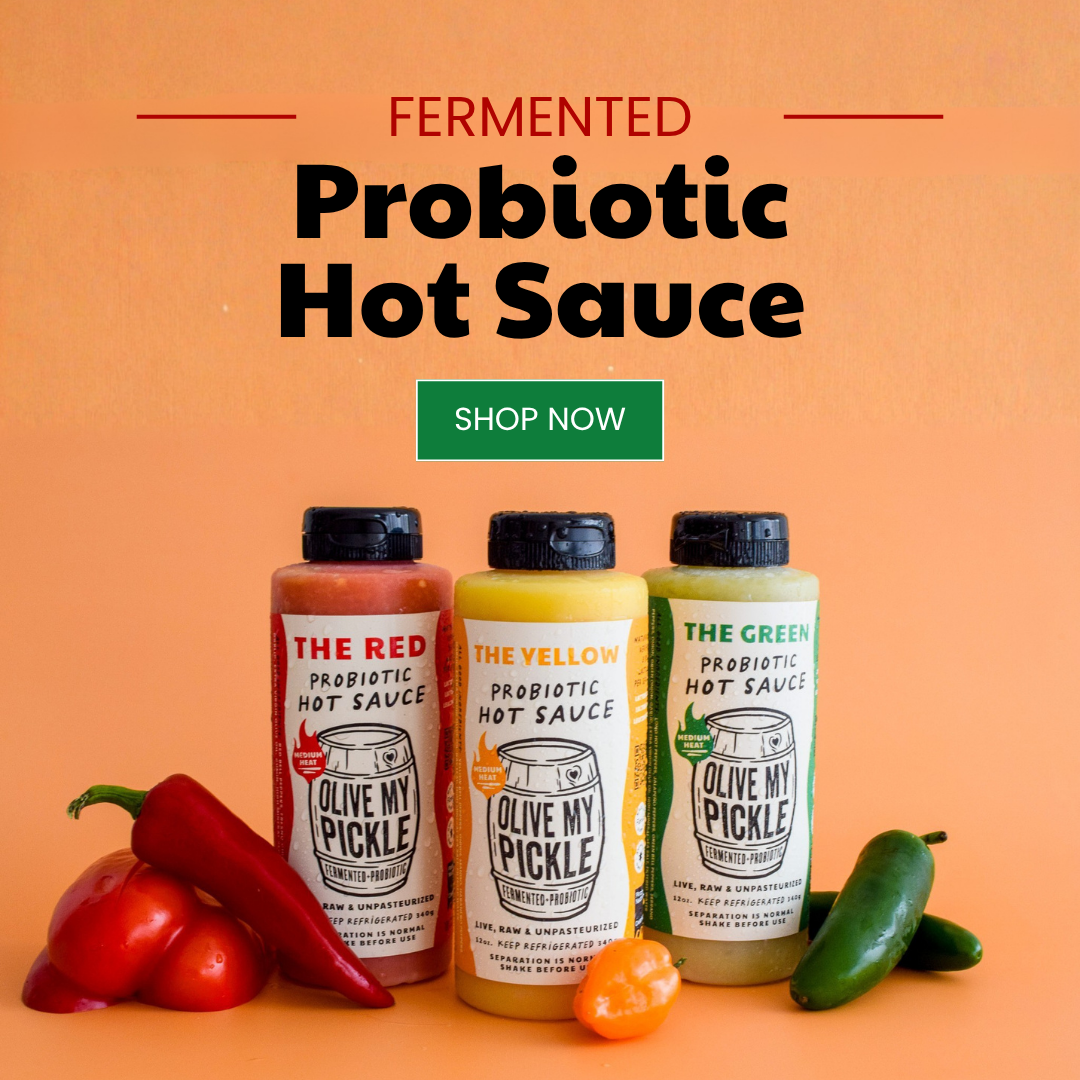 Three bottles of Olive My Pickle probiotic hot sauce (red, yellow, green) with fresh chili peppers on an orange background, featuring "Fermented Probiotic Hot S