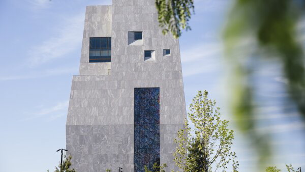 An exterior view of the Obama Presidential Center in Chicago. The building is gray with blue windows. 
