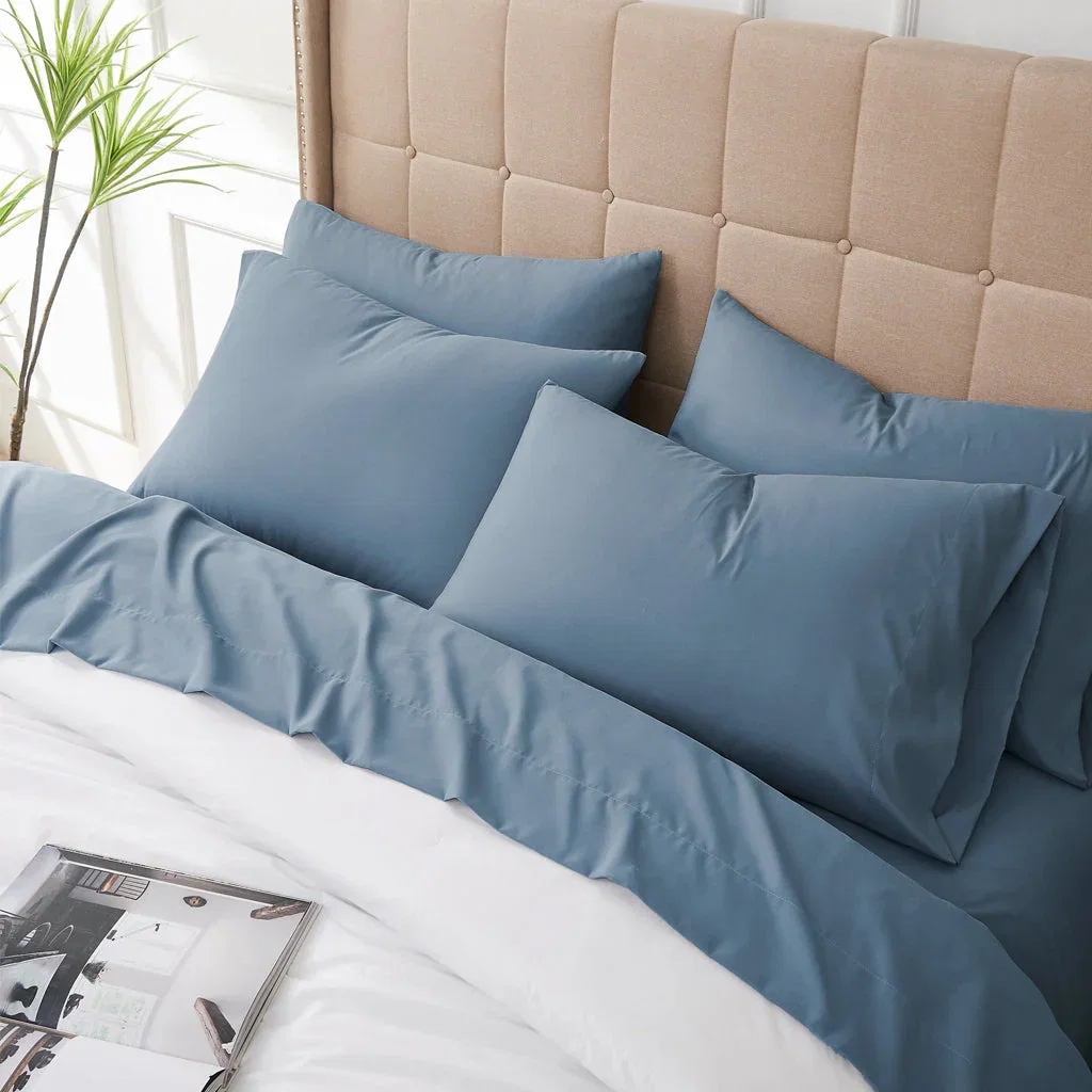 Southshore Fine Linens blue bedding set with pillows on beige upholstered headboard in bright bedroom