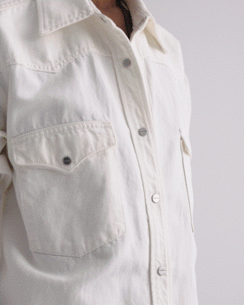 GIF of a model in a white top and skirt walking.
