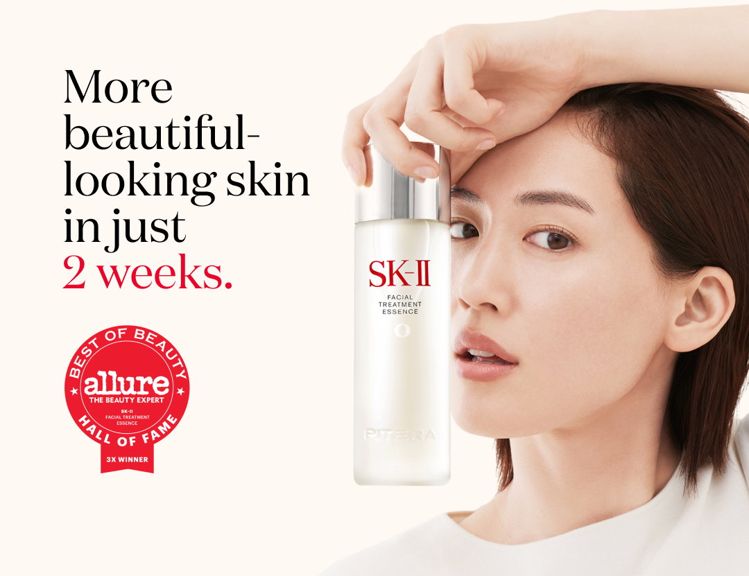 Woman holding SK-II Facial Treatment Essence bottle next to her face with text “More beautiful-looking skin in just 2 weeks” and Allure Best of Beauty Hall of Fame badge.