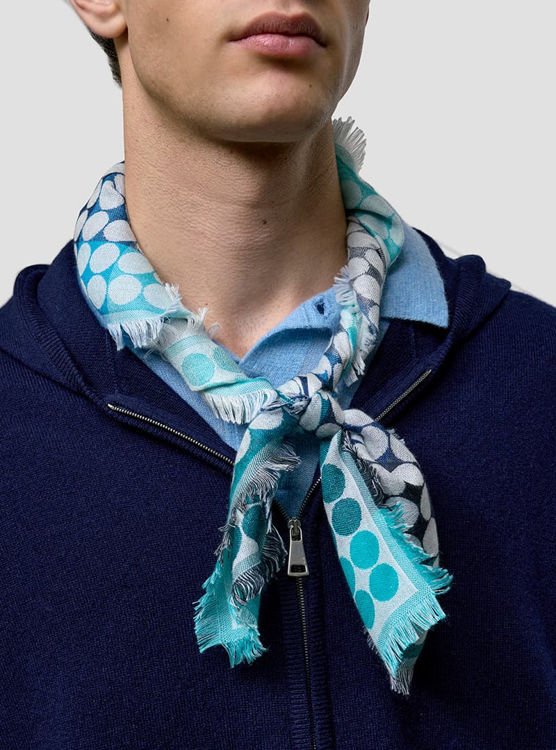 close up of a man wearing a patterned blue neck scarf
