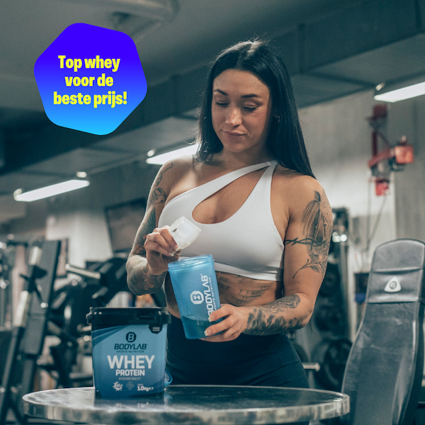 an image of a woman drinking water while standing in a gym