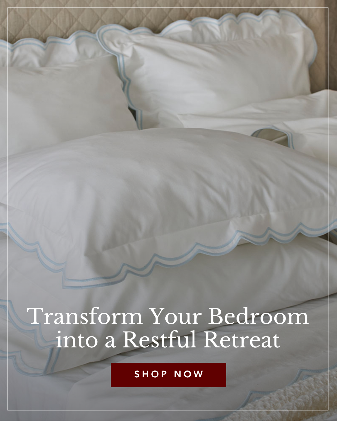 White bed linens with light blue scalloped embroidered edges arranged on a bed with a quilted headboard.