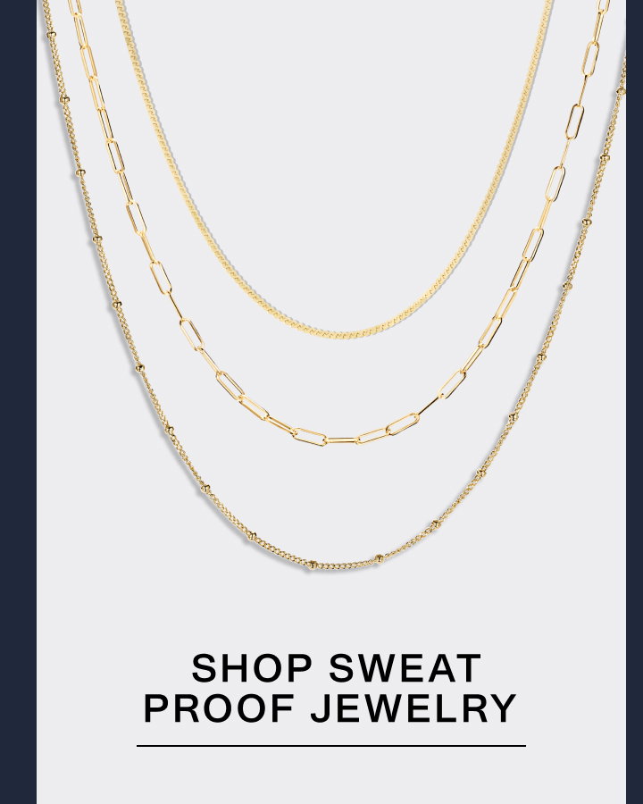Three layered Mejuri gold chain necklaces on a light grey background — Shop Sweat Proof Jewelry.