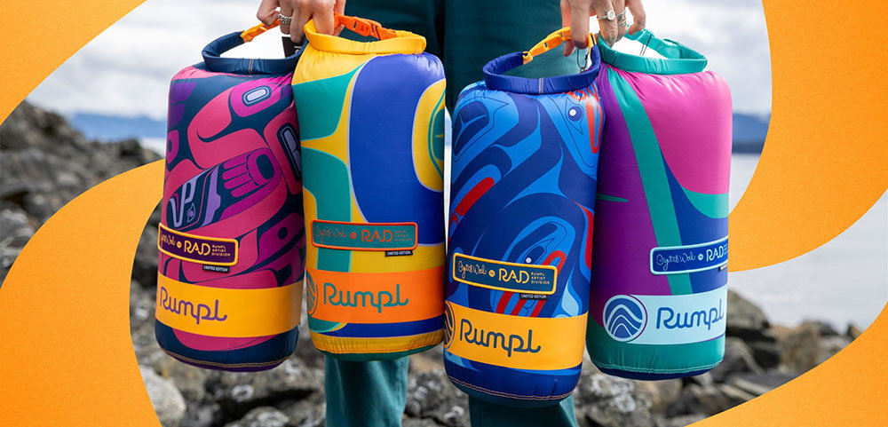 Crystal Worl holds 4 OG Puffy Blankets in their stuff sacks