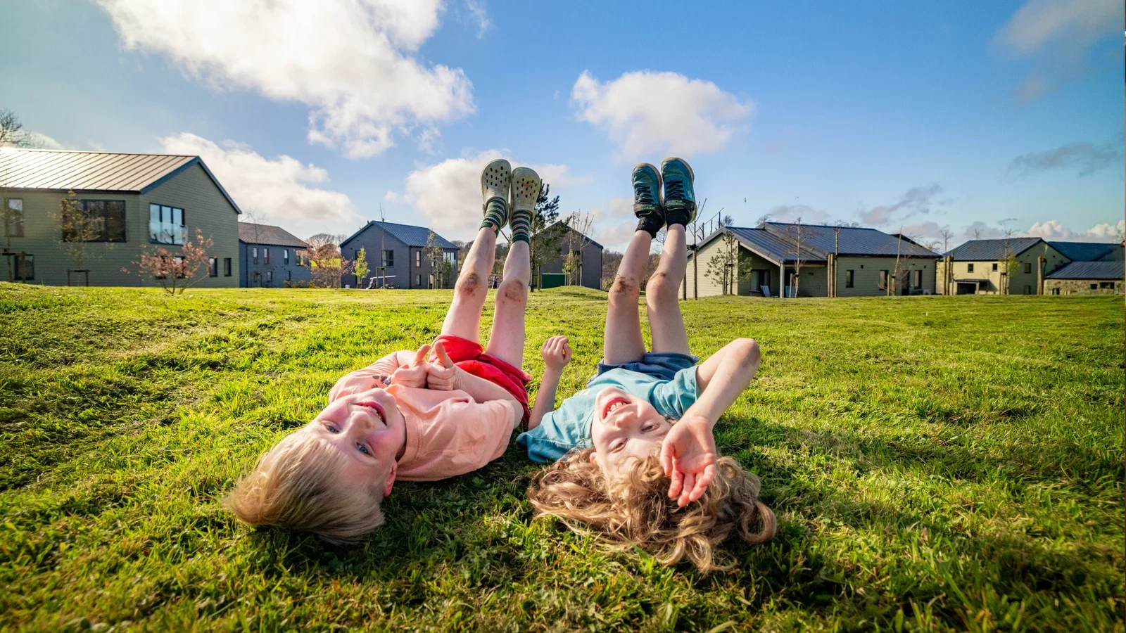 siblings playing on grass on summer day