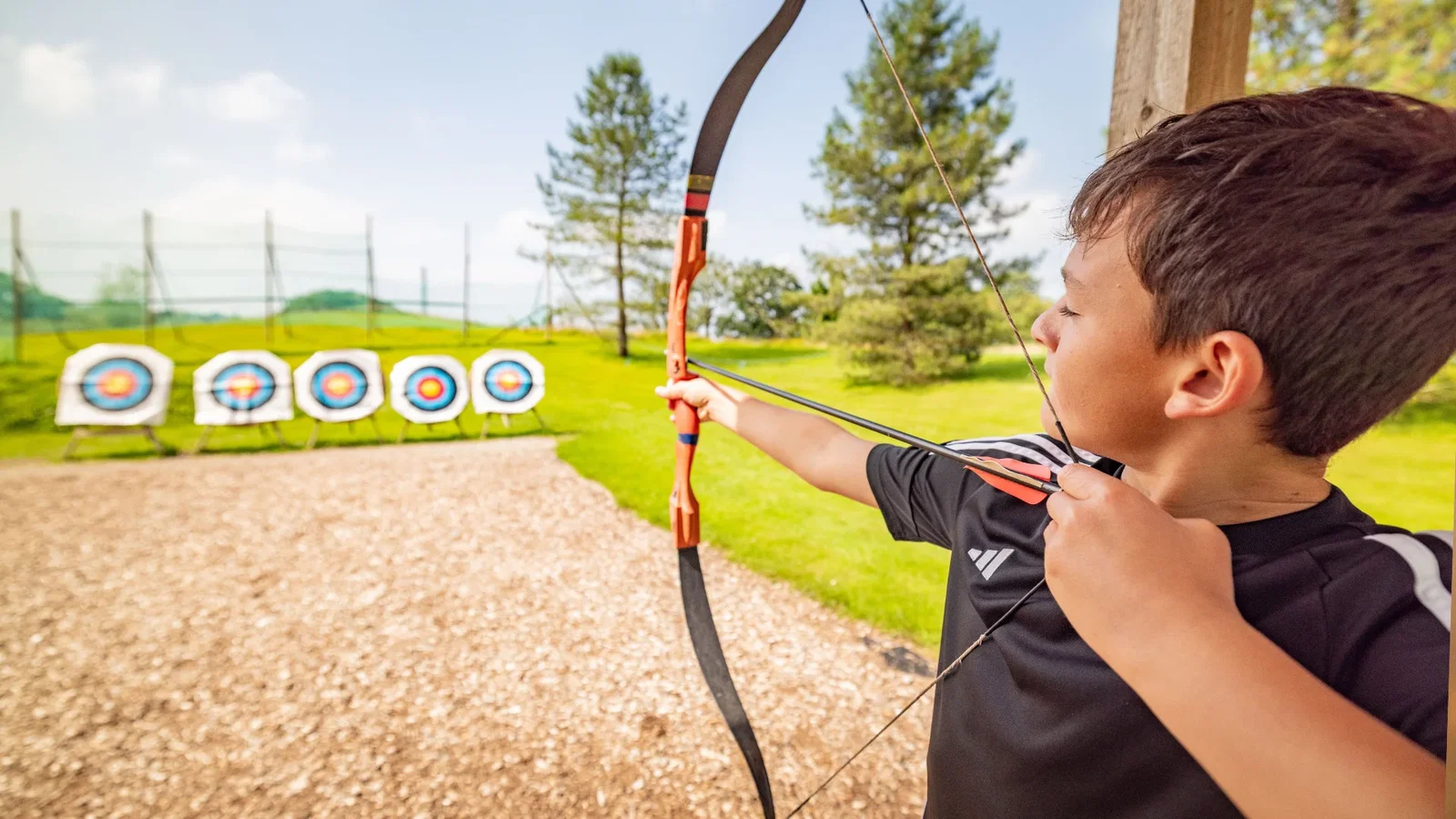 Boy holding a bow and arrow at archery