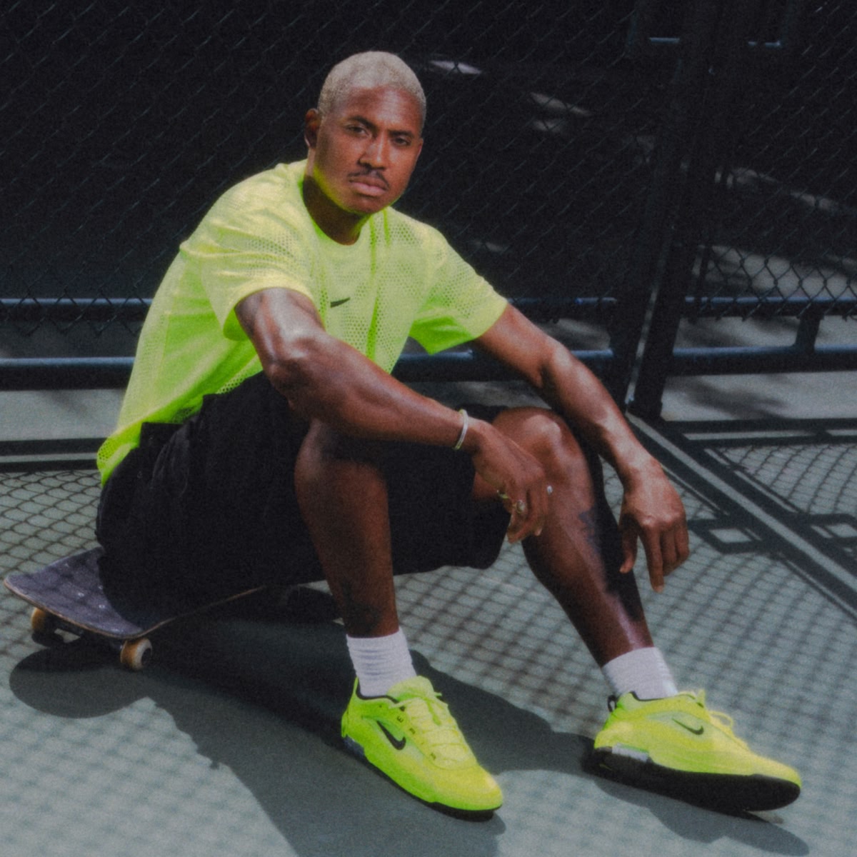 Shop the Nike SB Air Max Ishod Premium Volt | A model wearing an optic yellow shirt and the shoes.